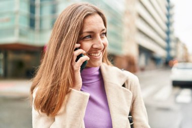 Young woman executive talking on the smartphone at street