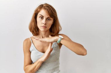 Güzel beyaz kadın, izole edilmiş arka planda duruyor. Elleriyle jest yapıyor, hayal kırıklığına uğramış ve ciddi bir yüz ifadesi var. 