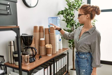 Kafkasyalı genç bir iş kadını elinde bir bardak kahve tutuyor.