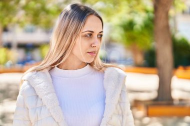 Young woman with relaxed expression standing at park