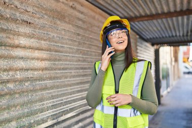 Genç, güzel İspanyol bir mimar sokakta akıllı telefondan konuşuyor.