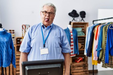 Perakende mağazasında müdür olarak çalışan gri saçlı son sınıf öğrencisi komik bir ifadeyle dilini dışarı çıkartıyor. duygu kavramı. 