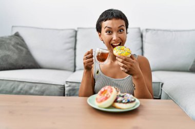 Genç İspanyol kadın evde kahvaltı ederken kendine güler yüzlü.