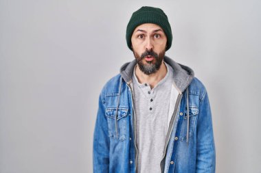 Yün şapka takan İspanyol dövmeli genç bir adam. Şaşırtıcı bir ifade, korku ve heyecan dolu bir yüz ifadesi var.. 