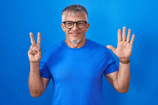 Homem Hispânico Com Cabelos Grisalhos Sobre Fundo Azul Mostrando Apontando — Fotografia de Stock