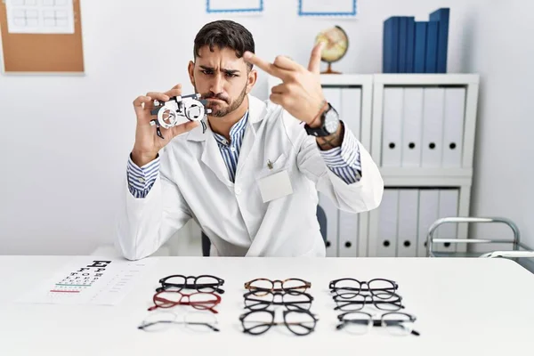 Young Optician Man Holding Optometry Glasses Showing Middle Finger Impolite — 图库照片