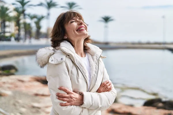 stock image Middle age woman standing with arms crossed gesture breathing at seaside