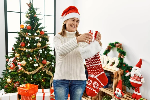 Middle Age Caucasian Woman Smiling Confident Inserting Gift Christmas Sock — Stock Photo, Image