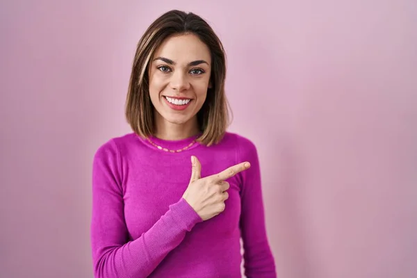 Hispanic Woman Standing Pink Background Cheerful Smile Face Pointing Hand — Stockfoto