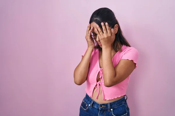Латиноамериканская Молодая Женщина Стоящая Розовом Фоне Очках Грустным Лицом Закрывающим — стоковое фото