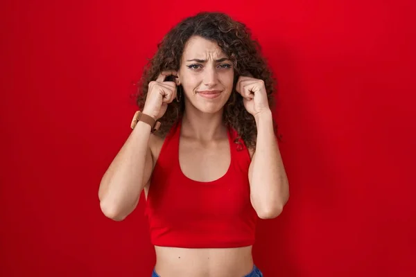 Hispanic Woman Curly Hair Standing Red Background Covering Ears Fingers — 图库照片