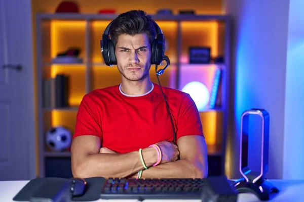 Fiatal Spanyol Férfi Videojátékozik Szkeptikus Ideges Rosszalló Kifejezés Arcon Keresztbe — Stock Fotó