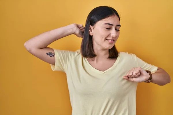 Hispanic Girl Wearing Casual Shirt Yellow Background Stretching Back Tired — Zdjęcie stockowe