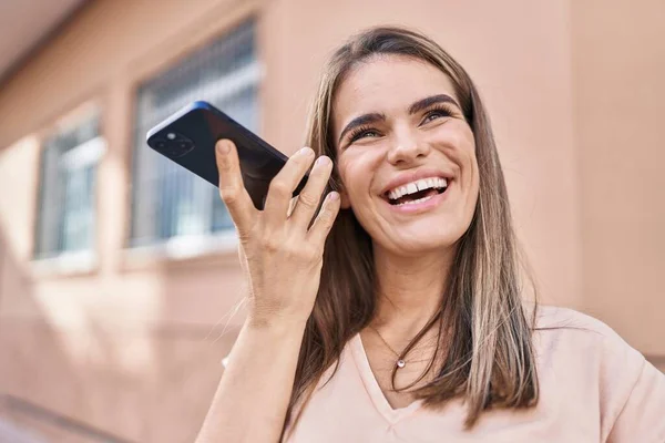若い美しいヒスパニック女性笑顔自信に満ちたリスニング音声メッセージによってスマートフォンでストリート — ストック写真