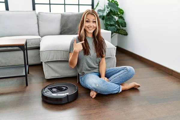 Young Caucasian Woman Sitting Home Vacuum Robot Pointing Finger One — Stock Photo, Image