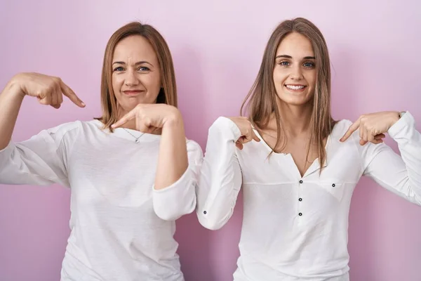 Middle Age Mother Young Daughter Standing Pink Background Looking Confident — Stockfoto