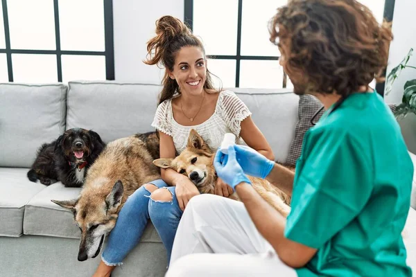 家で犬を検査する獣医師の制服を着た男と女 — ストック写真