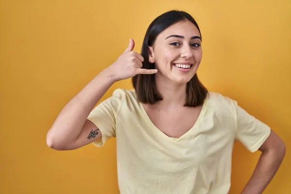Hispanic Girl Wearing Casual Shirt Yellow Background Smiling Doing Phone — Zdjęcie stockowe