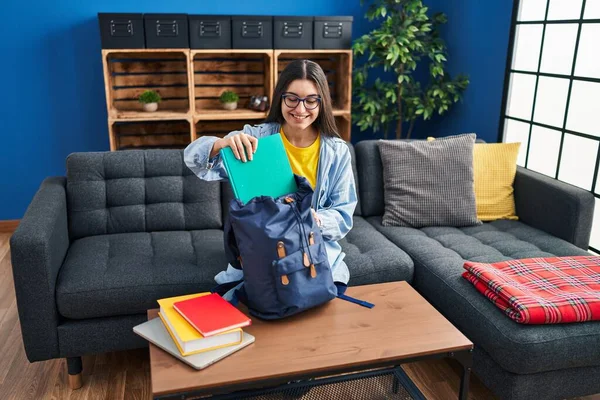 Young Hispanic Woman Student Holding Books Backpack Sitting Sofa Home — Fotografia de Stock