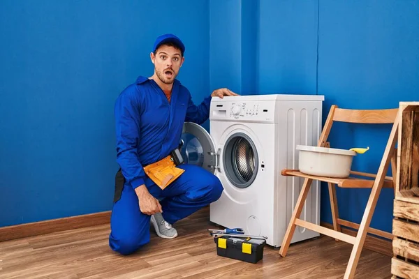 Ung Latinamerikansk Man Arbetar Tvättmaskin Rädd Och Förvånad Med Öppen — Stockfoto