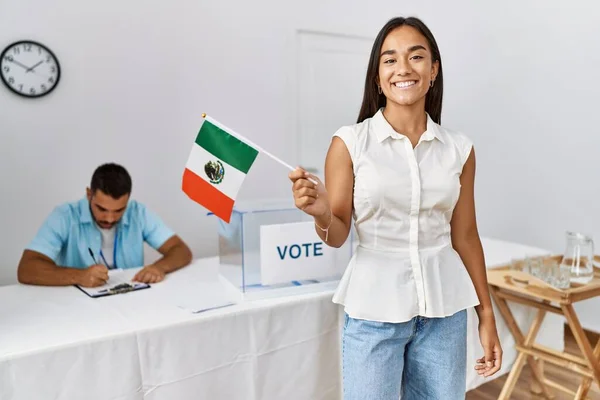 Young mexican voter woman smiling happy holding mexico flag at electoral college.