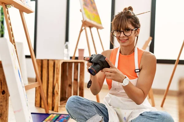 若いヒスパニック系の女性はアートスタジオで描くために写真を撮る — ストック写真