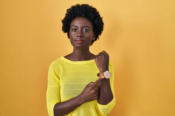 African Young Woman Standing Yellow Studio Hurry Pointing Watch Time — Foto de Stock