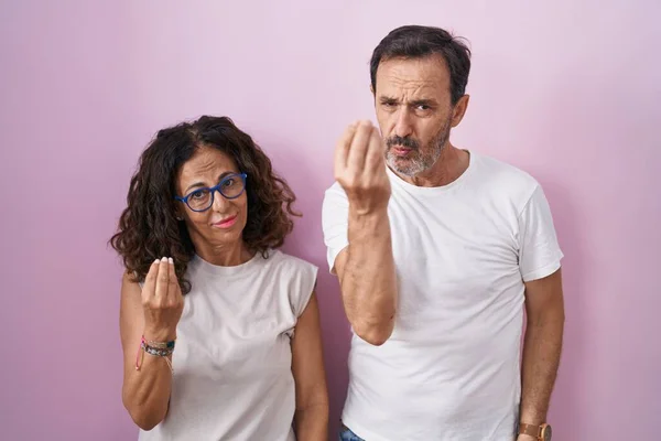 Middelbare Leeftijd Hispanic Paar Samen Roze Achtergrond Doen Italiaanse Gebaar — Stockfoto