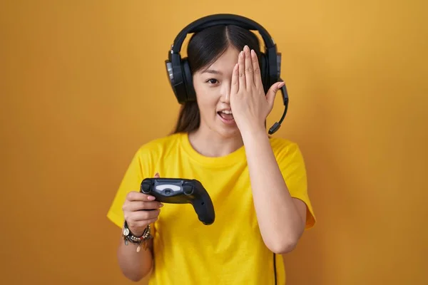 中国年轻女子手牵着一只眼睛玩电子游戏 脸上挂着自信的笑容 还有令人惊讶的情绪 — 图库照片