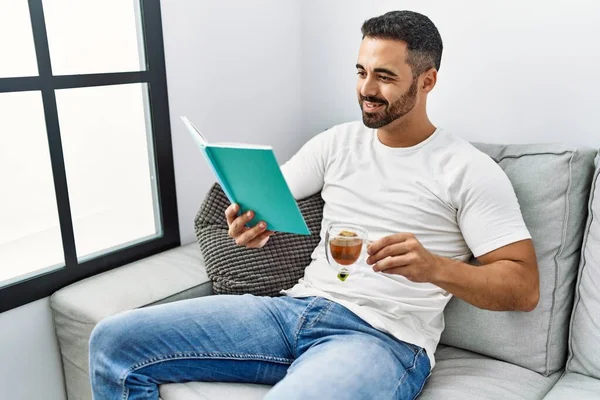 Young Hispanic Man Reading Book Drinking Tea Home — Photo