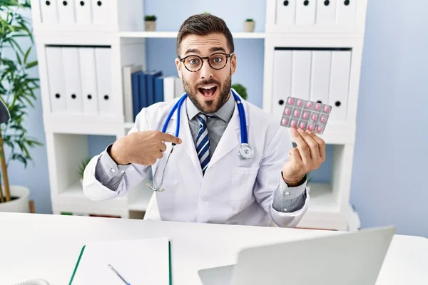 Handsome Hispanic Man Wearing Doctor Uniform Holding Prescription Pills Pointing — Stock Photo, Image