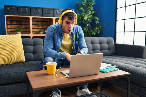 Young Hispanic Man Using Laptop Home Scared Amazed Open Mouth — Fotografia de Stock