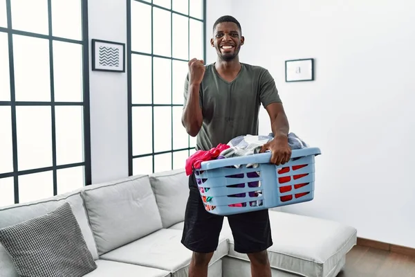 Young African American Man Doing Laundry Holding Basket Screaming Proud — Foto de Stock