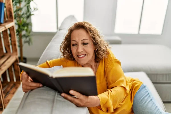 Orta Yaşlı Beyaz Kadın Kitap Okuyor Evdeki Kanepede Oturuyor — Stok fotoğraf