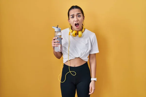 Ung Sydasiatisk Kvinna Bär Sportkläder Dricksvatten Chockansikte Ser Skeptisk Och — Stockfoto
