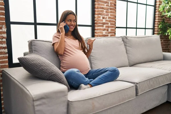 Mujer Embarazada Joven Teniendo Conversación Hablando Teléfono Inteligente Apuntando Pulgar —  Fotos de Stock