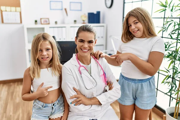 Pediatrician Woman Working Clinic Two Little Girls Smiling Happy Pointing — Stok fotoğraf