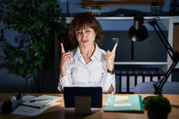 Mujer Mediana Edad Que Trabaja Oficina Por Noche Señalando Hacia —  Fotos de Stock