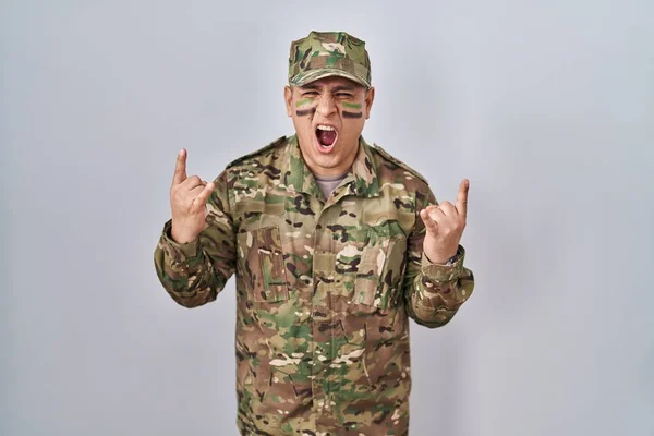 Spaanse Jongeman Camouflage Legeruniform Schreeuwend Met Gekke Uitdrukking Rocksymbool Met — Stockfoto