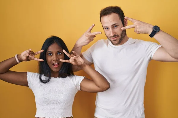 Interracial Couple Standing Yellow Background Doing Peace Symbol Fingers Face — Foto Stock