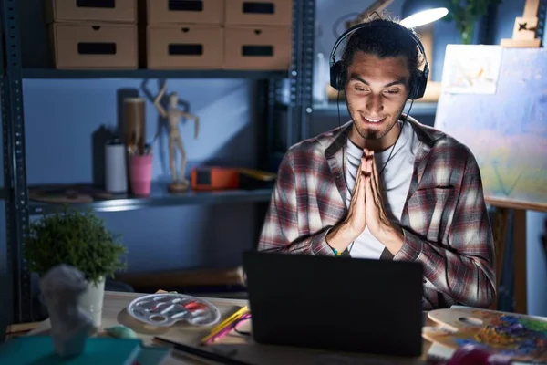 Young Hispanic Man Sitting Art Studio Laptop Late Night Praying — 图库照片