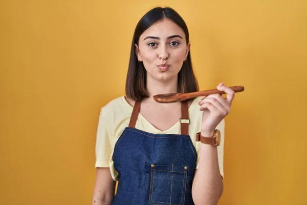 Hispanic Girl Eating Healthy Wooden Spoon Puffing Cheeks Funny Face — Zdjęcie stockowe