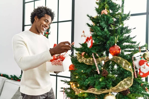 Joven Afroamericano Hombre Sonriendo Feliz Decorando Árbol Navidad Casa —  Fotos de Stock