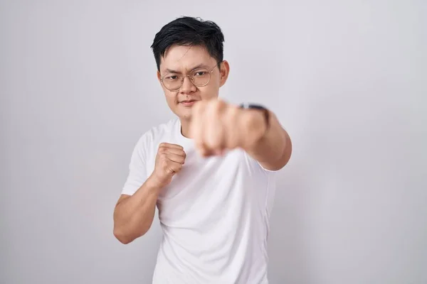 Young Asian Man Standing White Background Punching Fist Fight Aggressive — Zdjęcie stockowe