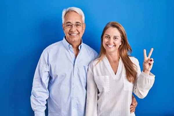 Medelåldern Latinamerikanskt Par Står Över Blå Bakgrund Visar Och Pekar — Stockfoto
