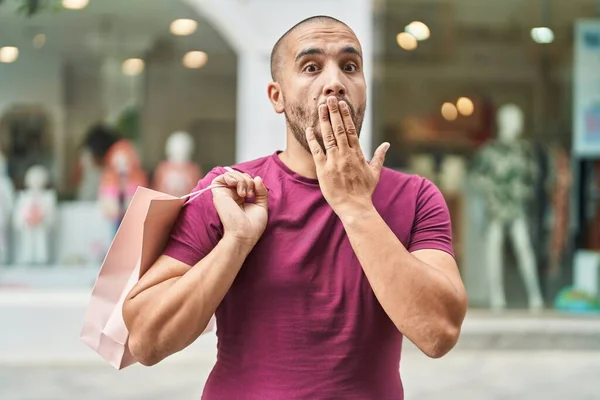 Hispanic Man Med Skägg Hålla Shoppingväskor Utomhus Täcker Munnen Med — Stockfoto