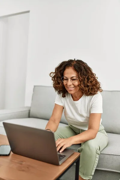 stock image Middle age hispanic woman smiling confident using laptop at home