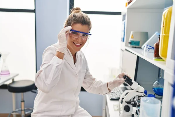 研究室で働く科学者の制服を着た若いブロンドの女性 — ストック写真