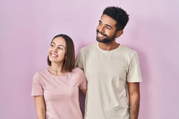 Young Hispanic Couple Together Pink Background Looking Away Side Smile — Stockfoto