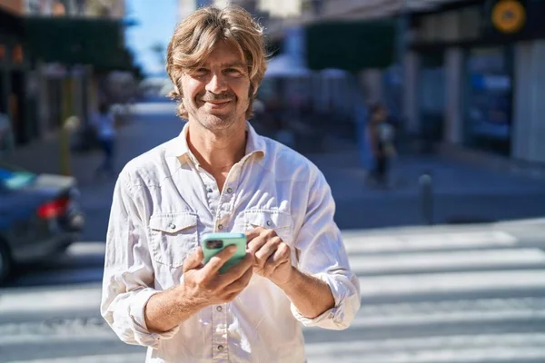 年轻人在街上用智能手机充满自信地微笑 — 图库照片